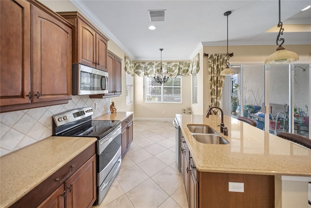 305 Siena Vista Pl, Sun City Center, FL 33573 - kitchen with appliances with stainless steel finishes, an island with sink, a chandelier, ornamental molding, and backsplash