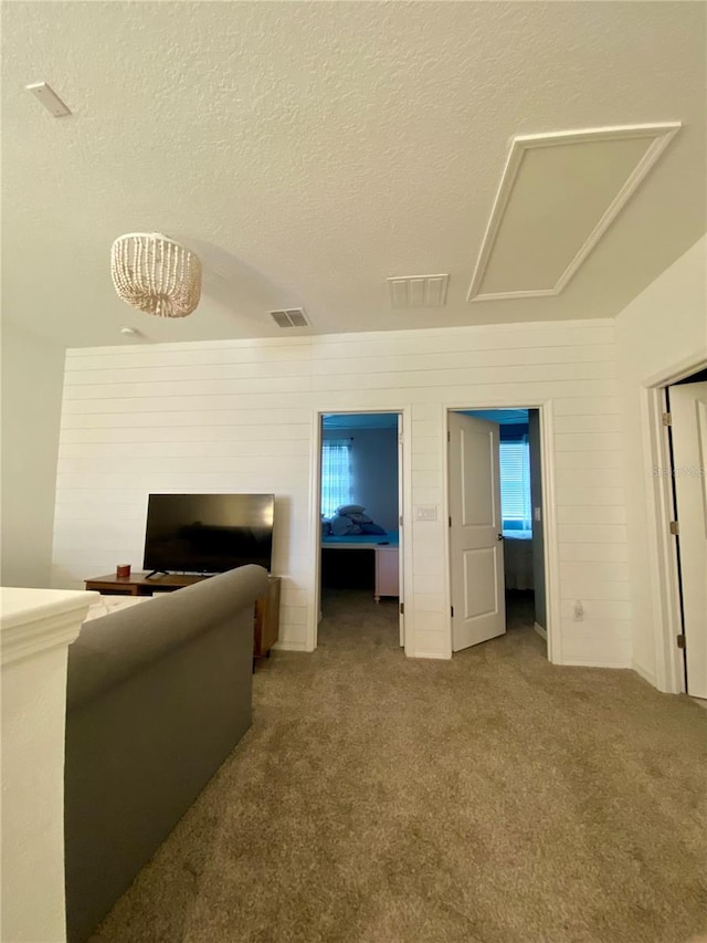 11613 Woodleaf Dr, Lakewood Ranch, FL 34211 - living room with a textured ceiling, carpet floors, and attic access