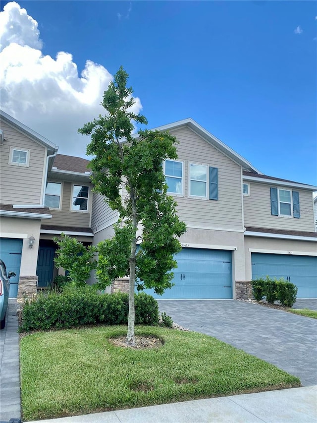 11613 Woodleaf Dr, Lakewood Ranch, FL 34211 - multi unit property featuring an attached garage, stone siding, driveway, stucco siding, and a front yard