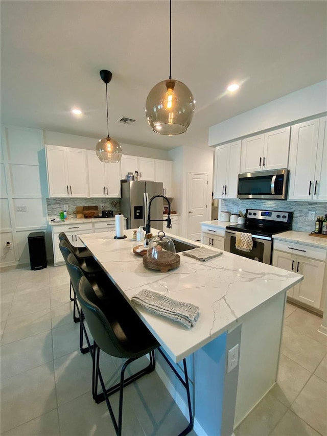 11613 Woodleaf Dr, Lakewood Ranch, FL 34211 - kitchen with stainless steel appliances, a sink, decorative backsplash, light tile patterned flooring, and light stone counters