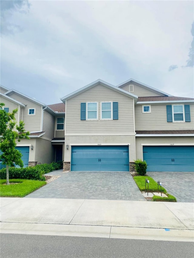 11613 Woodleaf Dr, Lakewood Ranch, FL 34211 - townhome / multi-family property with a garage, stucco siding, stone siding, and driveway