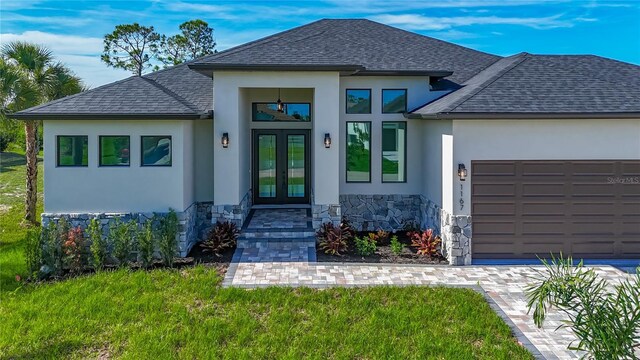1167 Boundary Blvd, Rotonda West, FL 33947 - view of front of property with french doors, stucco siding, stone siding, an attached garage, and a shingled roof