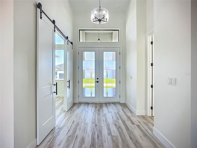 1167 Boundary Blvd, Rotonda West, FL 33947 - entrance foyer with plenty of natural light, light wood finished floors, a chandelier, french doors, and a high ceiling