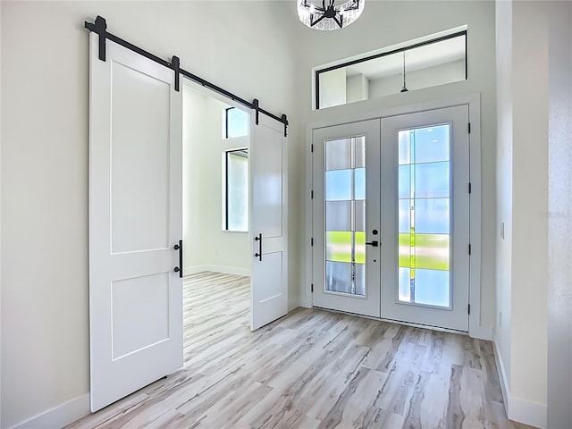 1167 Boundary Blvd, Rotonda West, FL 33947 - entrance foyer featuring french doors, a barn door, and light wood-type flooring