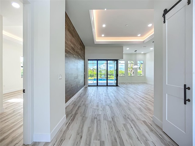1167 Boundary Blvd, Rotonda West, FL 33947 - spare room featuring a tray ceiling, light wood-style floors, recessed lighting, and a barn door