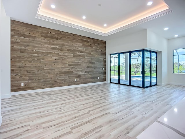 1167 Boundary Blvd, Rotonda West, FL 33947 - unfurnished room featuring wood walls, a tray ceiling, recessed lighting, light wood-type flooring, and an accent wall