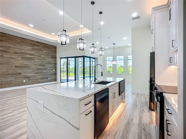 1167 Boundary Blvd, Rotonda West, FL 33947 - kitchen featuring black appliances, a large island with sink, a raised ceiling, recessed lighting, and light wood-type flooring