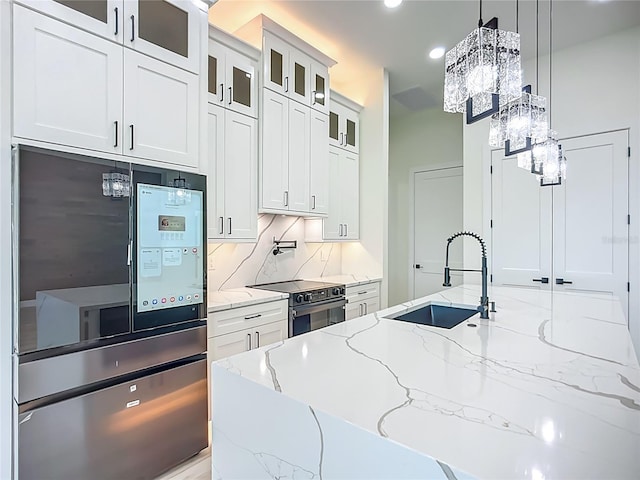 1167 Boundary Blvd, Rotonda West, FL 33947 - kitchen with range with electric cooktop, smart refrigerator, a chandelier, light stone countertops, and backsplash