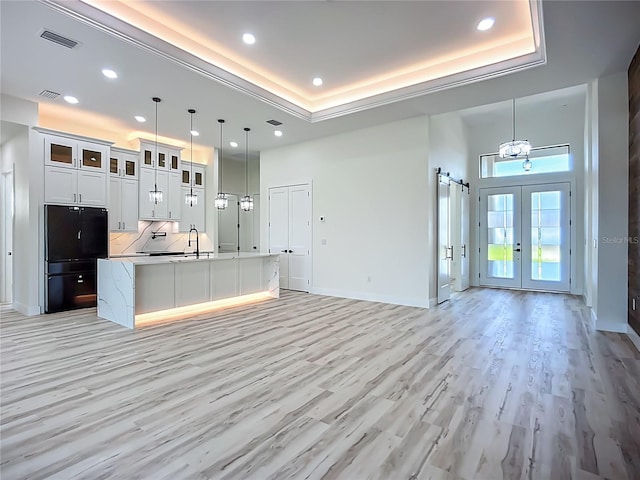 1167 Boundary Blvd, Rotonda West, FL 33947 - kitchen featuring freestanding refrigerator, light wood-type flooring, a kitchen island with sink, open floor plan, and recessed lighting