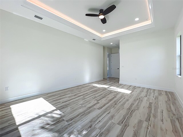 1167 Boundary Blvd, Rotonda West, FL 33947 - unfurnished room with a raised ceiling, ceiling fan, light wood finished floors, and recessed lighting