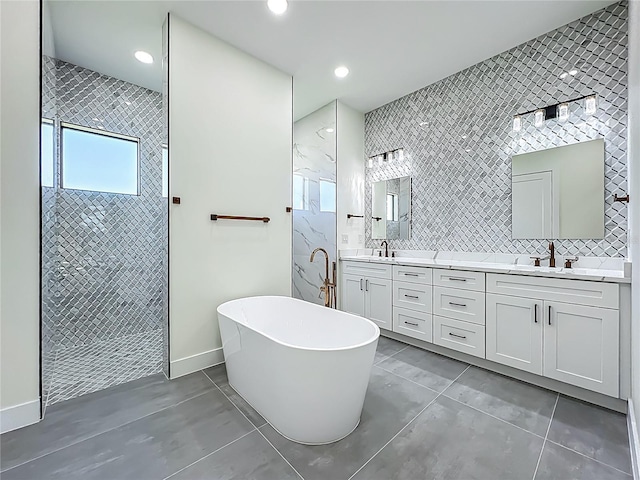 1167 Boundary Blvd, Rotonda West, FL 33947 - bathroom featuring a tile shower, a freestanding bath, double vanity, tile patterned flooring, and recessed lighting
