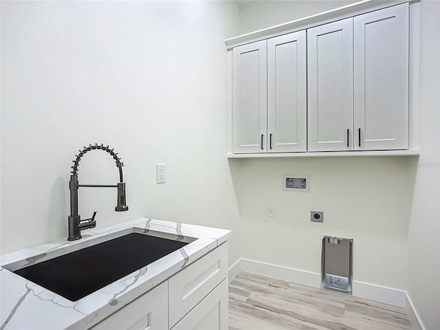 1167 Boundary Blvd, Rotonda West, FL 33947 - washroom featuring hookup for an electric dryer, hookup for a washing machine, light wood-style floors, and cabinet space