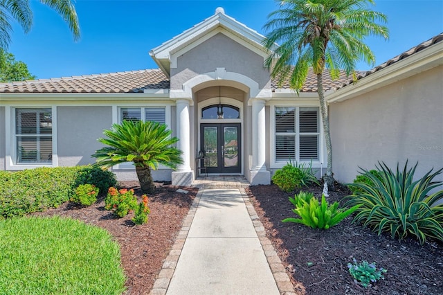 7302 Dunes Ct, Bradenton, FL 34202 - doorway to property featuring french doors, stucco siding, and a tiled roof