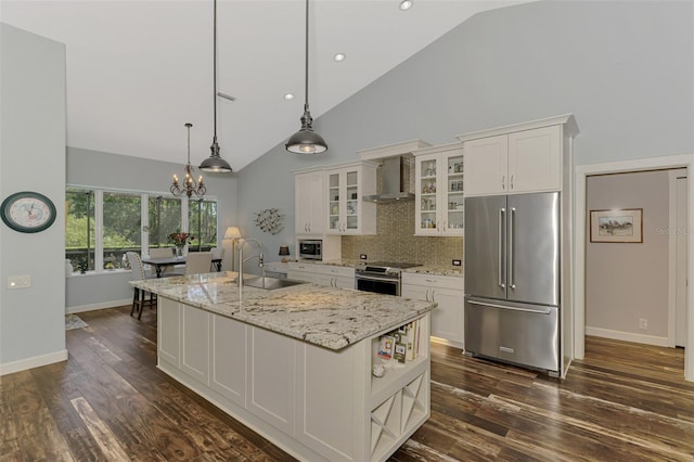 7302 Dunes Ct, Bradenton, FL 34202 - kitchen featuring stainless steel appliances, wall chimney exhaust hood, high vaulted ceiling, a chandelier, and white cabinetry