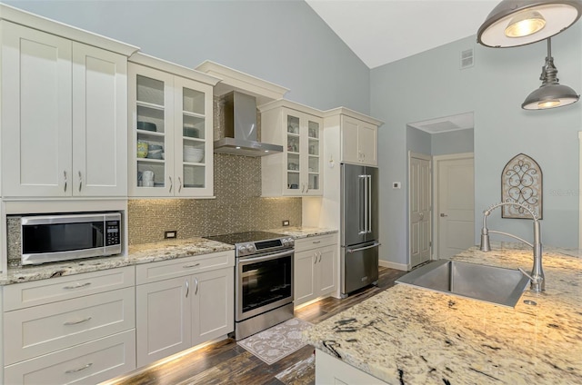 7302 Dunes Ct, Bradenton, FL 34202 - kitchen featuring stainless steel appliances, wall chimney range hood, decorative backsplash, dark wood-style flooring, and decorative light fixtures