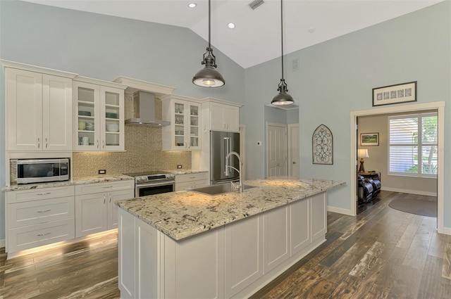 7302 Dunes Ct, Bradenton, FL 34202 - kitchen featuring wall chimney exhaust hood, stainless steel appliances, high vaulted ceiling, a center island with sink, and tasteful backsplash