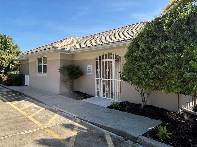 7302 Dunes Ct, Bradenton, FL 34202 - doorway to property with stucco siding and a tiled roof