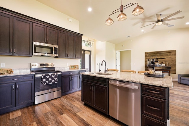 16630 Willow Point Ct, Alva, FL 33920 - kitchen featuring stainless steel appliances, a sink, open floor plan, wood finished floors, and lofted ceiling