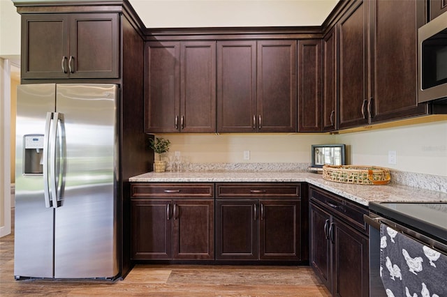 16630 Willow Point Ct, Alva, FL 33920 - kitchen featuring stainless steel appliances, light wood-style floors, dark brown cabinets, and light stone countertops