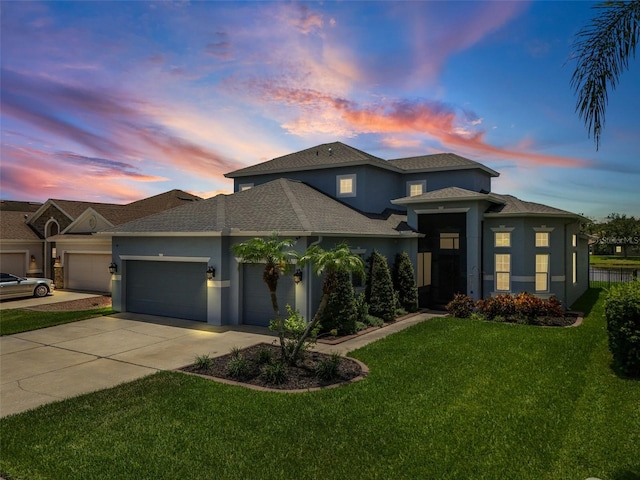 2347 123rd Pl E, Parrish, FL 34219 - prairie-style house with stucco siding, an attached garage, a yard, driveway, and a shingled roof