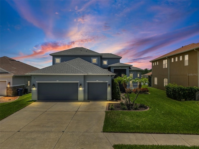 2347 123rd Pl E, Parrish, FL 34219 - view of front facade with stucco siding, an attached garage, a shingled roof, driveway, and a lawn