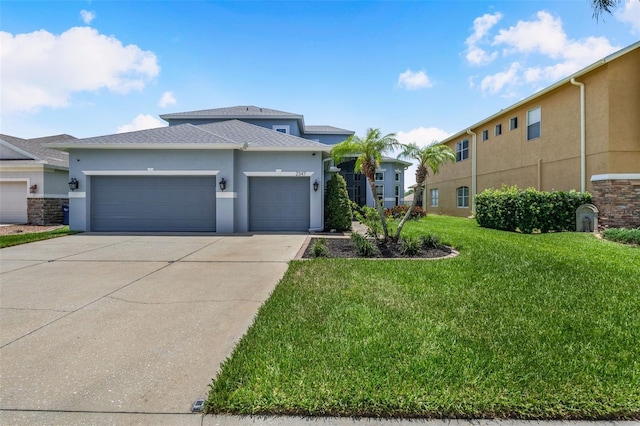 2347 123rd Pl E, Parrish, FL 34219 - prairie-style house featuring stucco siding, an attached garage, a front lawn, driveway, and a shingled roof