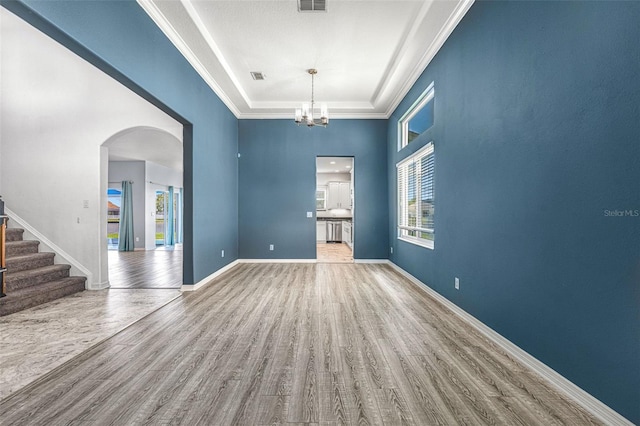 2347 123rd Pl E, Parrish, FL 34219 - empty room featuring wood finished floors, stairway, arched walkways, a high ceiling, and a chandelier