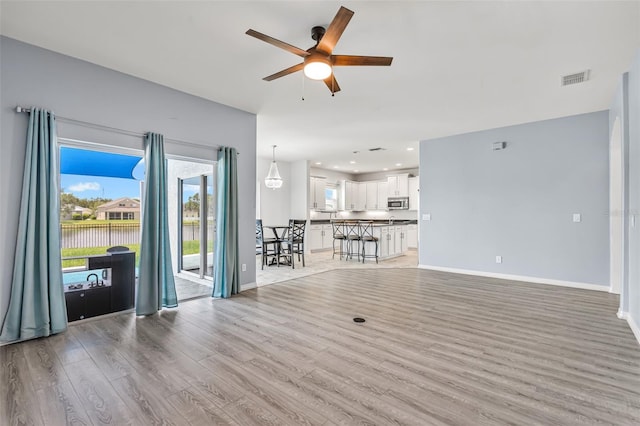 2347 123rd Pl E, Parrish, FL 34219 - unfurnished living room with ceiling fan, light wood-style flooring, recessed lighting, and a water view