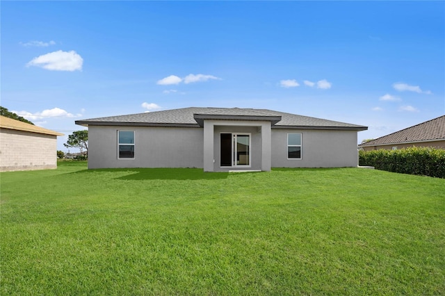 22033 Voltair Ave, Port Charlotte, FL 33954 - back of property with stucco siding, a lawn, and a shingled roof