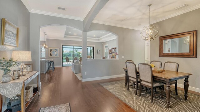 13220 Swiftwater Way, Lakewood Ranch, FL 34211 - dining room featuring arched walkways, wood finished floors, a chandelier, and ornamental molding