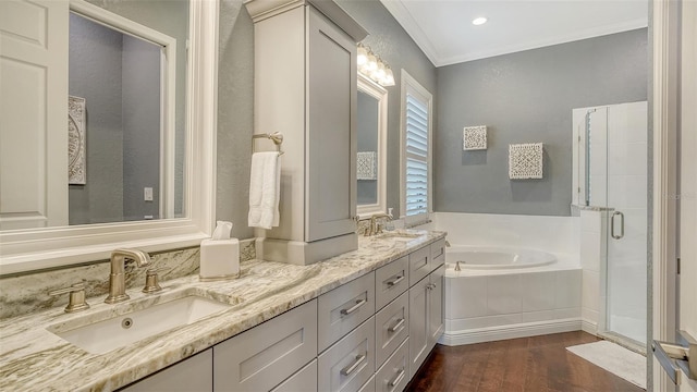 13220 Swiftwater Way, Lakewood Ranch, FL 34211 - bathroom featuring a garden tub, wood finished floors, double vanity, crown molding, and a stall shower