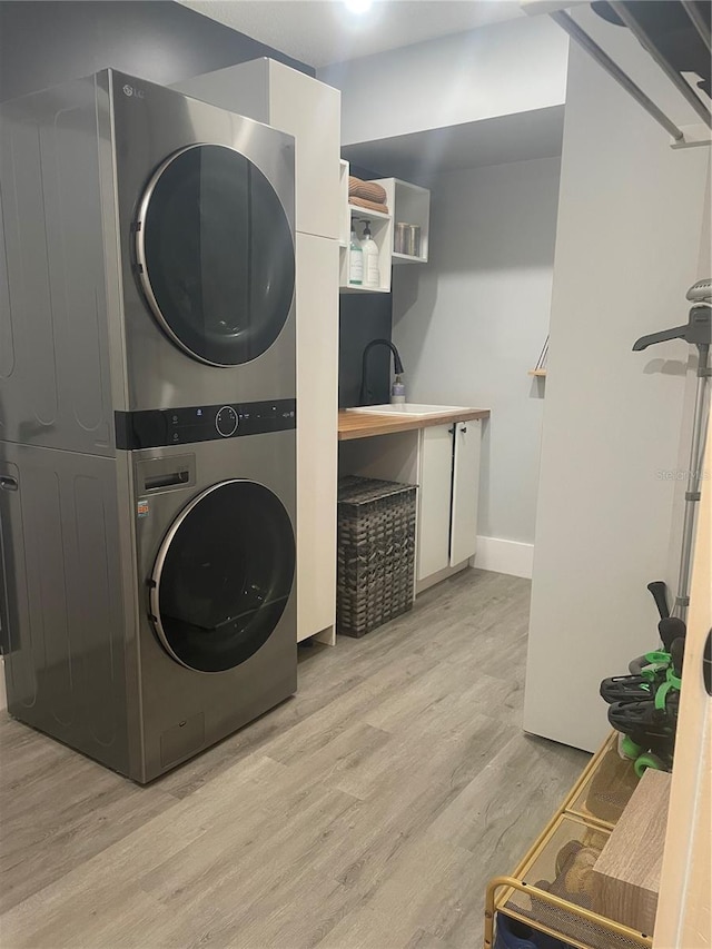 5848 Milton Ave, Sarasota, FL 34243 - washroom with stacked washer and clothes dryer and light wood finished floors