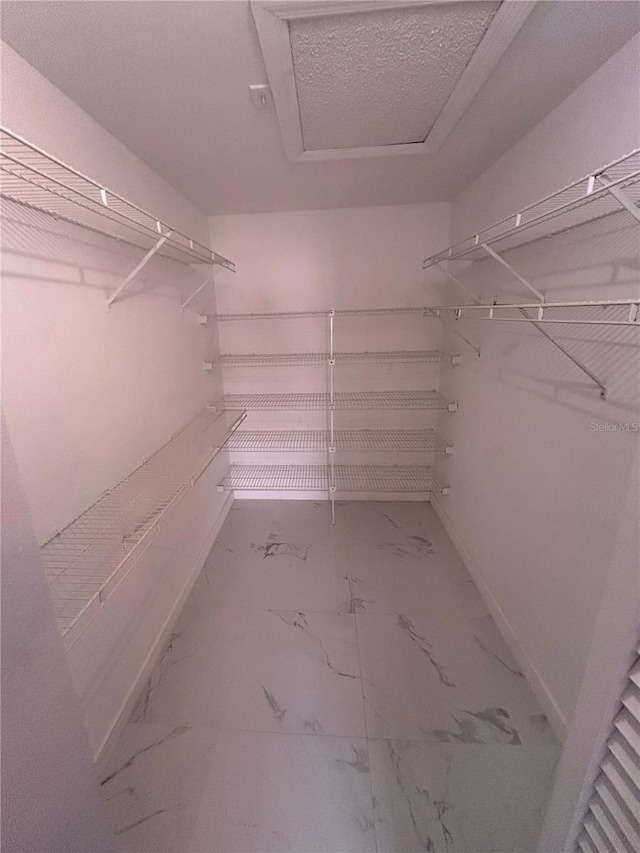 5848 Milton Ave, Sarasota, FL 34243 - spacious closet with marble look tile flooring and attic access
