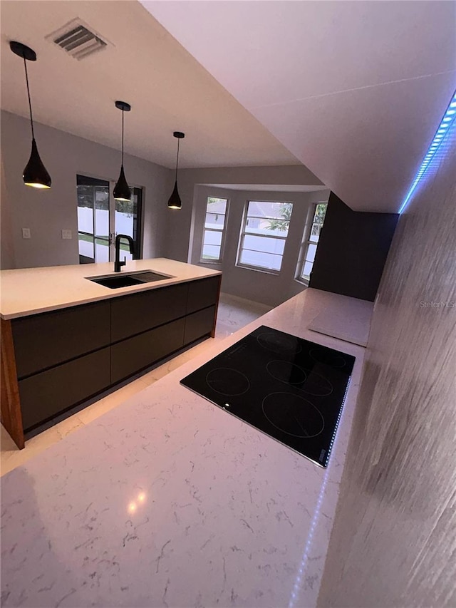 5848 Milton Ave, Sarasota, FL 34243 - kitchen featuring black electric stovetop, modern cabinets, light countertops, and decorative light fixtures