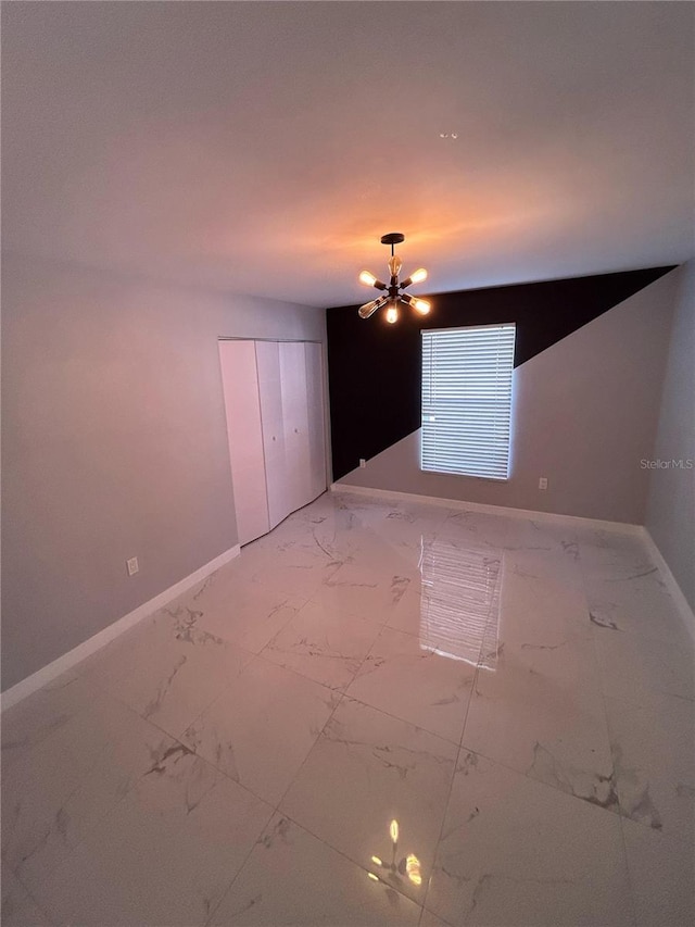 5848 Milton Ave, Sarasota, FL 34243 - unfurnished room with light marble finish floors and a chandelier