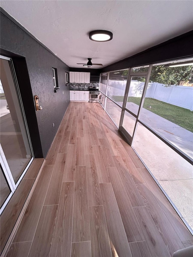 5848 Milton Ave, Sarasota, FL 34243 - hallway with light wood finished floors, plenty of natural light, and a textured wall