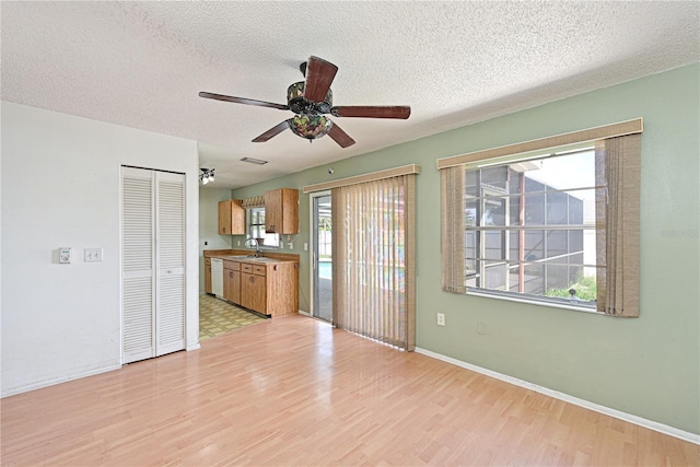 6406 16th Avenue Dr W, Bradenton, FL 34209 - kitchen with dishwasher, ceiling fan, light wood-type flooring, a textured ceiling, and brown cabinetry