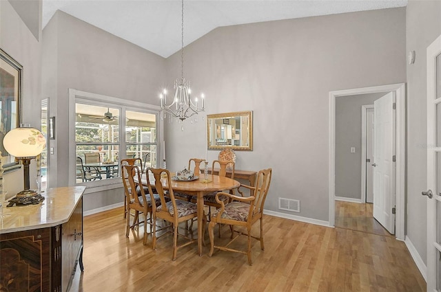 4733 Spring Meadow Ln, Sarasota, FL 34233 - dining room with light wood finished floors, high vaulted ceiling, and a chandelier
