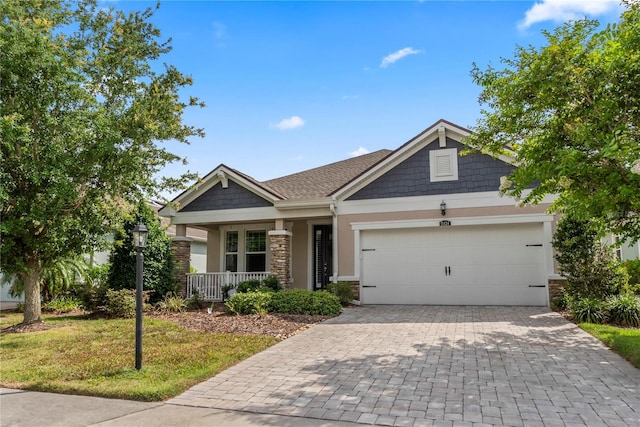 11434 Spring Gate Trl, Bradenton, FL 34211 - craftsman-style home with covered porch, stone siding, decorative driveway, an attached garage, and stucco siding