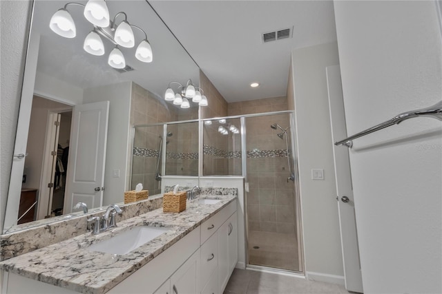 11434 Spring Gate Trl, Bradenton, FL 34211 - bathroom featuring double vanity, a shower stall, a chandelier, tile patterned flooring, and a spacious closet