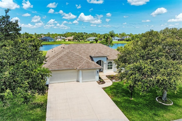 208 147th St NE, Bradenton, FL 34212 - view of front of home featuring a garage, a water view, driveway, stucco siding, and a front yard