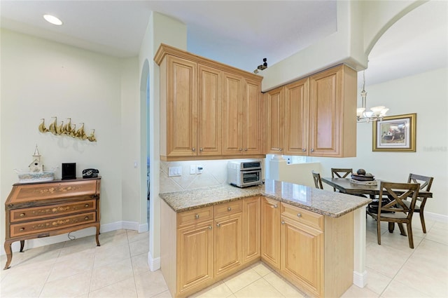 208 147th St NE, Bradenton, FL 34212 - kitchen with arched walkways, light stone countertops, a chandelier, light tile patterned floors, and recessed lighting