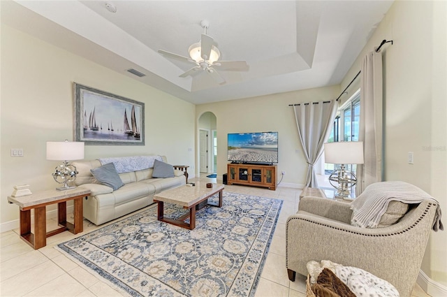 208 147th St NE, Bradenton, FL 34212 - living area with a tray ceiling, light tile patterned floors, and arched walkways