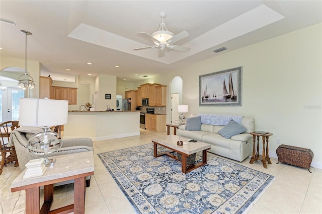 208 147th St NE, Bradenton, FL 34212 - living area with arched walkways, light tile patterned flooring, a ceiling fan, a tray ceiling, and recessed lighting