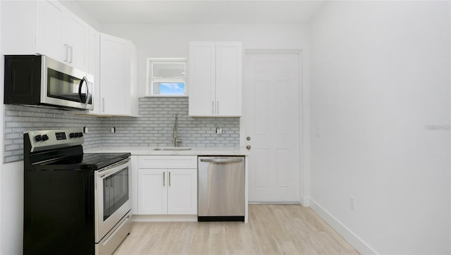 4796 Duncan Rd, Punta Gorda, FL 33982 - kitchen featuring appliances with stainless steel finishes, light countertops, backsplash, and white cabinetry