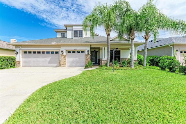 6423 Royal Tern Cir, Lakewood Ranch, FL 34202 - view of front of property with a front lawn, concrete driveway, stone siding, and a garage