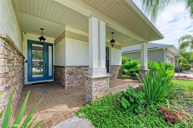 6423 Royal Tern Cir, Lakewood Ranch, FL 34202 - view of exterior entry with stucco siding, a porch, and stone siding