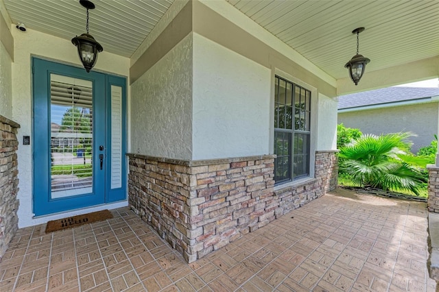 6423 Royal Tern Cir, Lakewood Ranch, FL 34202 - doorway to property featuring stucco siding, covered porch, and a surveillance system