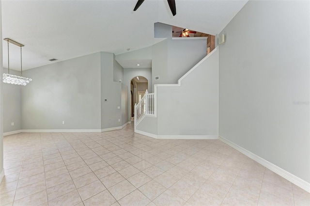 6423 Royal Tern Cir, Lakewood Ranch, FL 34202 - unfurnished living room featuring arched walkways, ceiling fan, stairway, light tile patterned floors, and high vaulted ceiling