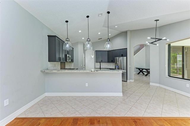 6423 Royal Tern Cir, Lakewood Ranch, FL 34202 - kitchen featuring appliances with stainless steel finishes, lofted ceiling, tasteful backsplash, a chandelier, and a peninsula
